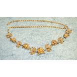 A Victorian gold and pearl set necklace of eleven alternately linked flowerhead and leaf motifs on