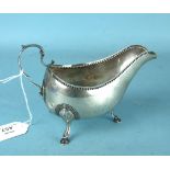 An 18th Century Irish sauce boat, the plain body with pressed beaded rim and scroll handle on hoof
