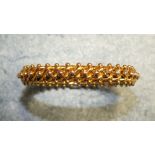 A 15ct gold hinged bangle in the form of a beaded curb link chain over a two-bar frame with