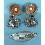 A pair of silver plated chamber sticks with embossed rim decoration, on circular bases, with