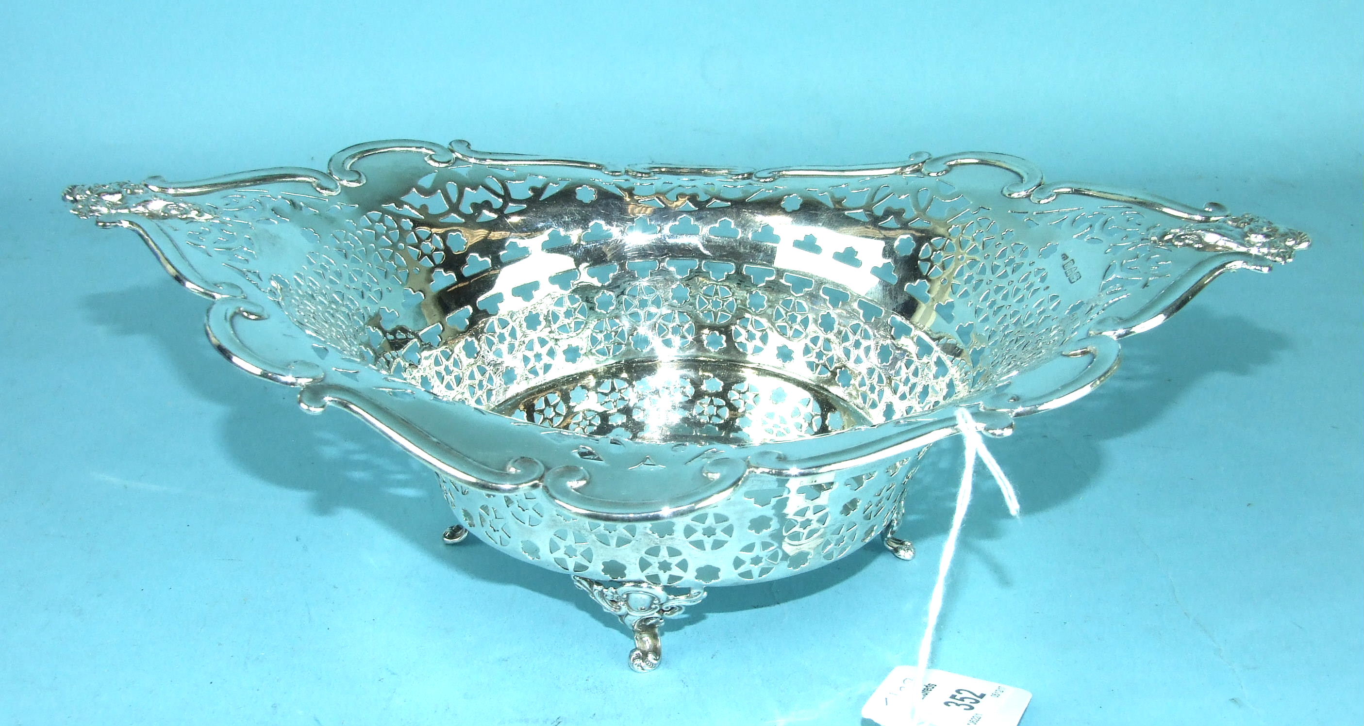 An Edwardian pierced silver basket of lozenge shape raised on pierced scroll feet, 30 x 22cm,