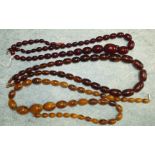 A string of graduated cherry amber type Bakelite beads and two other strings of simulated amber