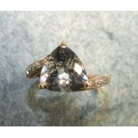 An aquamarine and diamond dress ring claw set a triangle-cut pale aquamarine in 9ct gold cross