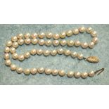 A string of fifty-four uniformly-sized cultured pearls, 7mm diameter approx, to a 9ct gold clasp.