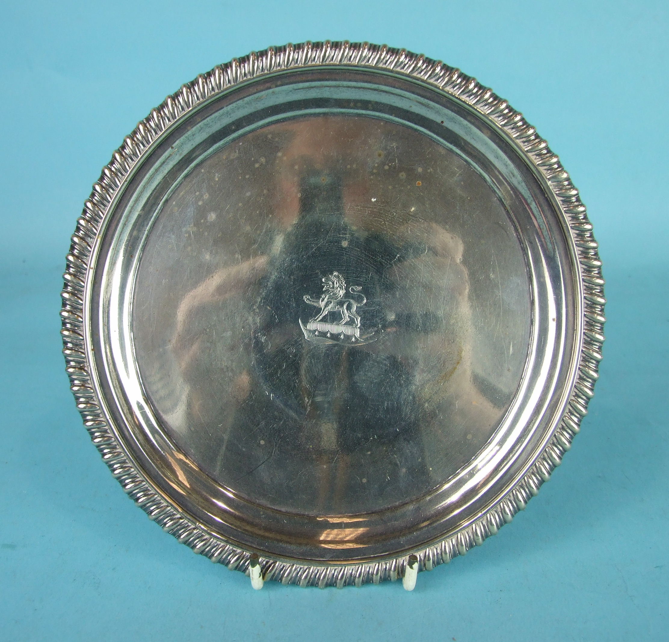 A small George III silver salver with gadrooned rim and raised on three cast feet, 17.7cm