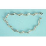 A 9ct white gold bracelet of wavy links, each alternate link set seven 8/8 cut diamond points, 19cm,