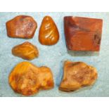 Five pieces of unpolished amber and an amber pendant, total weight 249g approx.