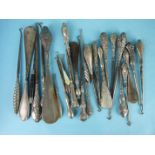 A large collection of silver-handled shoehorns and button hooks and one Bakelite and steel hook, (