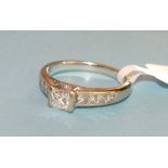 A solitaire diamond ring, channel set a princess cut diamond of approx 0.47cts between shoulders