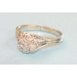 A diamond flower head cluster ring claw set seven brilliant cut diamonds in 14K white gold mount,