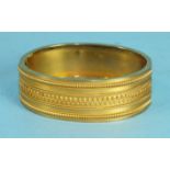 A Victorian gold Etruscan style hinged bangle, the front with cannetile decoration, 1.8cm wide,