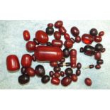 A quantity of loose Bakelite graduated cherry amber-type beads, largest 6 x 3cm and others, dark red