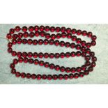 Two necklaces of uniformly sized spherical cherry amber type beads, each 11mm diameter, 43cm and