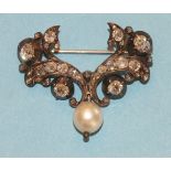 A 19th century diamond brooch of scrolling form, set old brilliant and rose cut diamonds with a