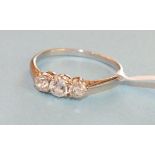 A three-stone diamond ring, the old brilliant cut diamonds claw set in white metal mount, size O,