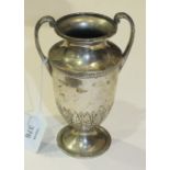 A silver urn with leaf capped scroll handles on loaded base, 16cm high, London 1910.