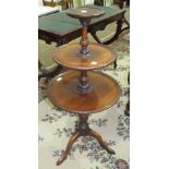 A Georgian-style mahogany three-tier circular dumb waiter with turned columns, on tripod base,