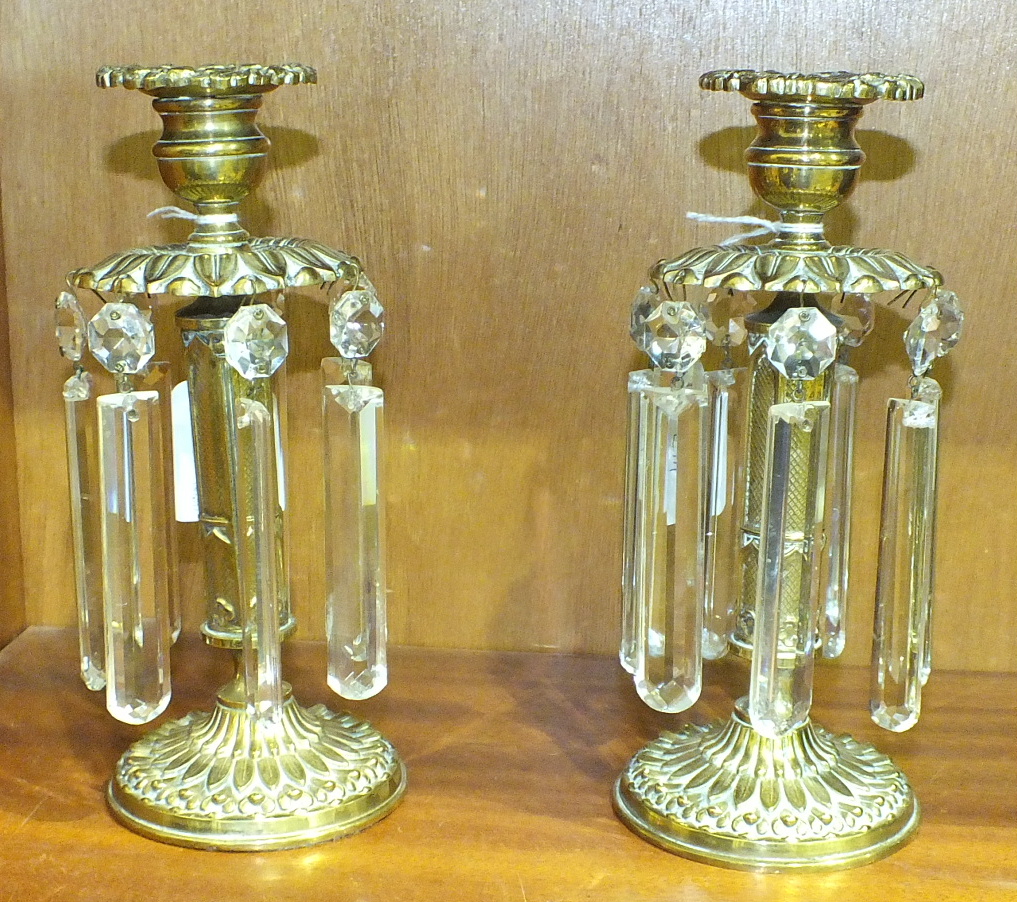 A pair of brass chenets, each candle sconce above a leaf-moulded disc with cut-glass drops, 20cm, (