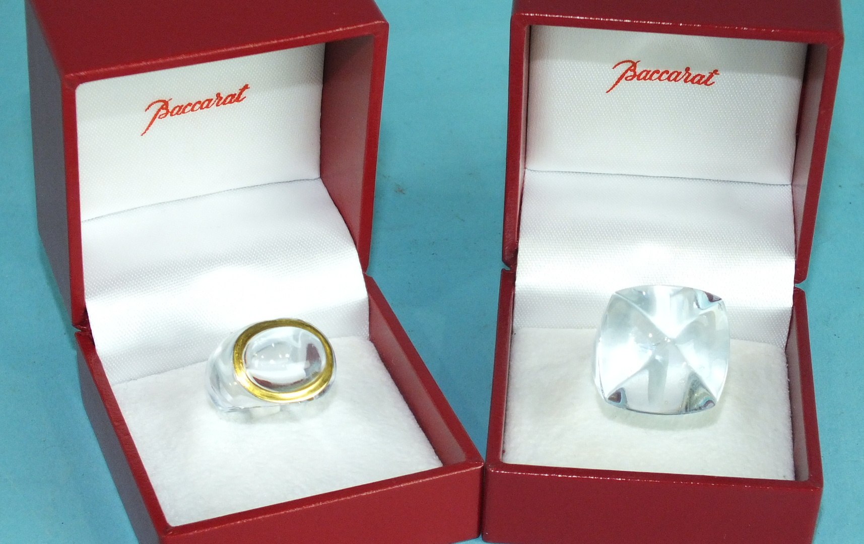 Baccarat, a clear glass bombe ring and a pale blue glass ring, both signed and boxed, (2), sizes J