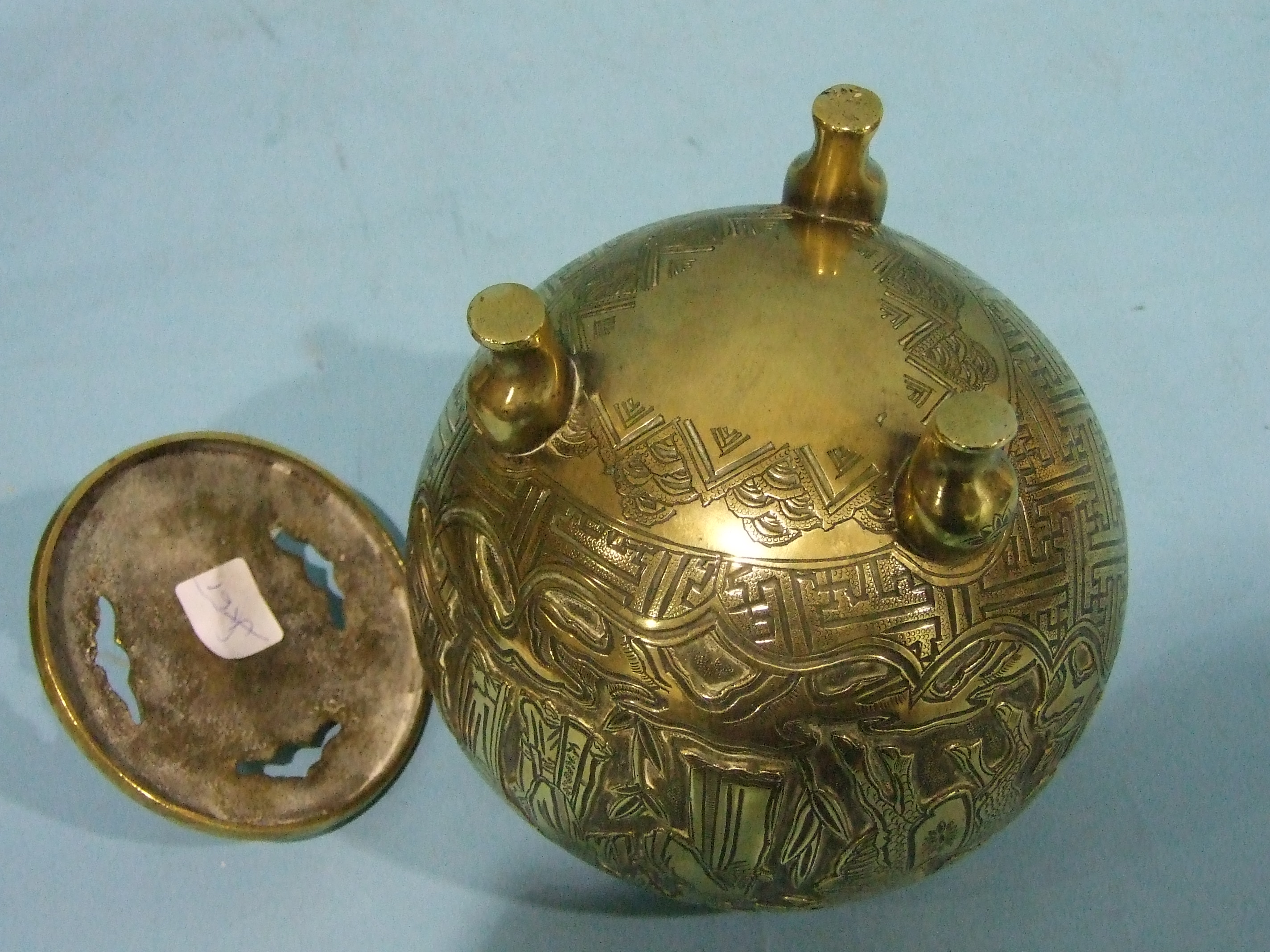 A 19th century Chinese globular brass censer and cover engraved with figures on balconies and in