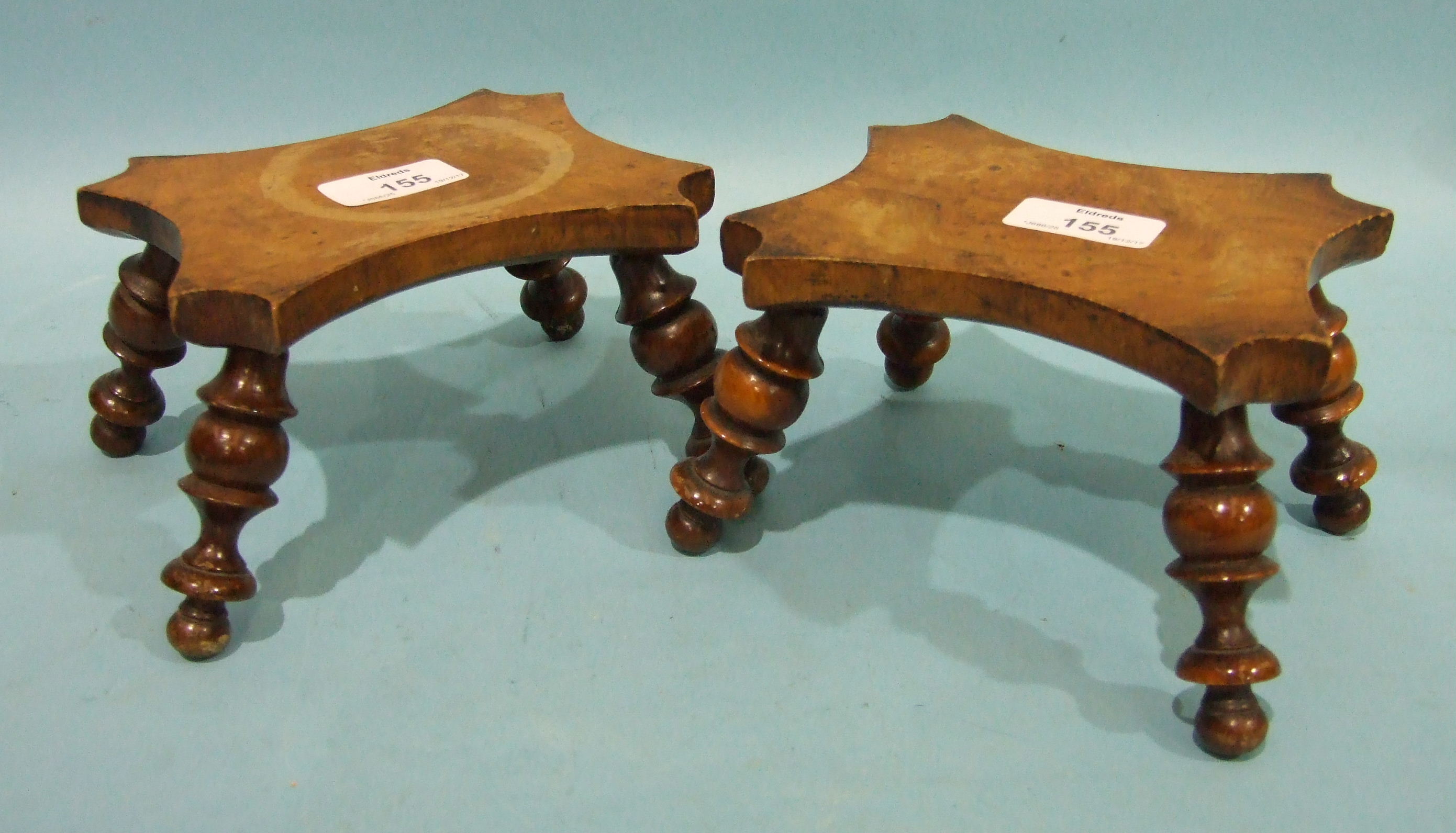 A pair of burr walnut treen trivets, each concave shape top on four turned splayed legs, 16cm