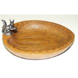 An ash wood nut bowl in the shape of a hazel nut surmounted by a silver squirrel, 20cm long.