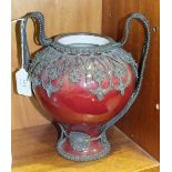 A glazed baluster pottery vase with overall silver filigree mount forming handles, 24cm high.