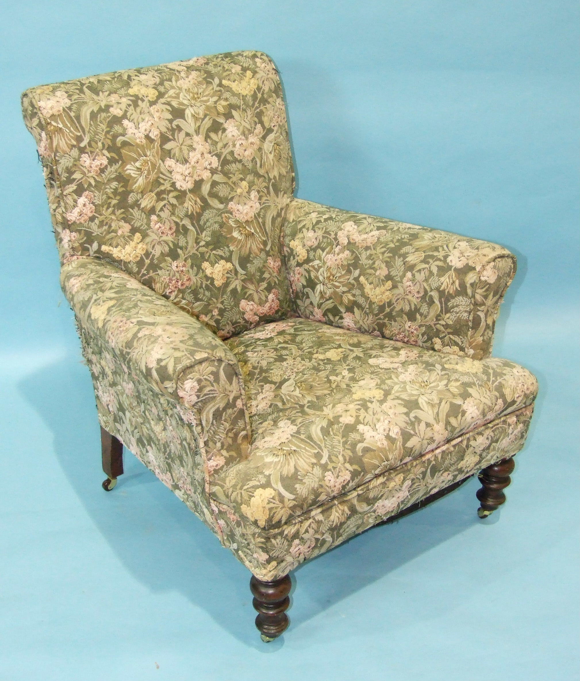 A late-19th/early-20th century upholstered armchair with turned arms and front legs and a stained