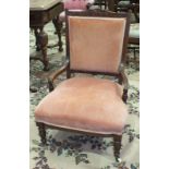 An Edwardian wood-framed upholstered-seat-and-back nursing chair on turned front legs.