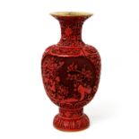 Rotlackvase. CHINA, 20. Jh. Messingkorpus in Balusterform mit floralem Schnitzlackdekor, H ca. 31