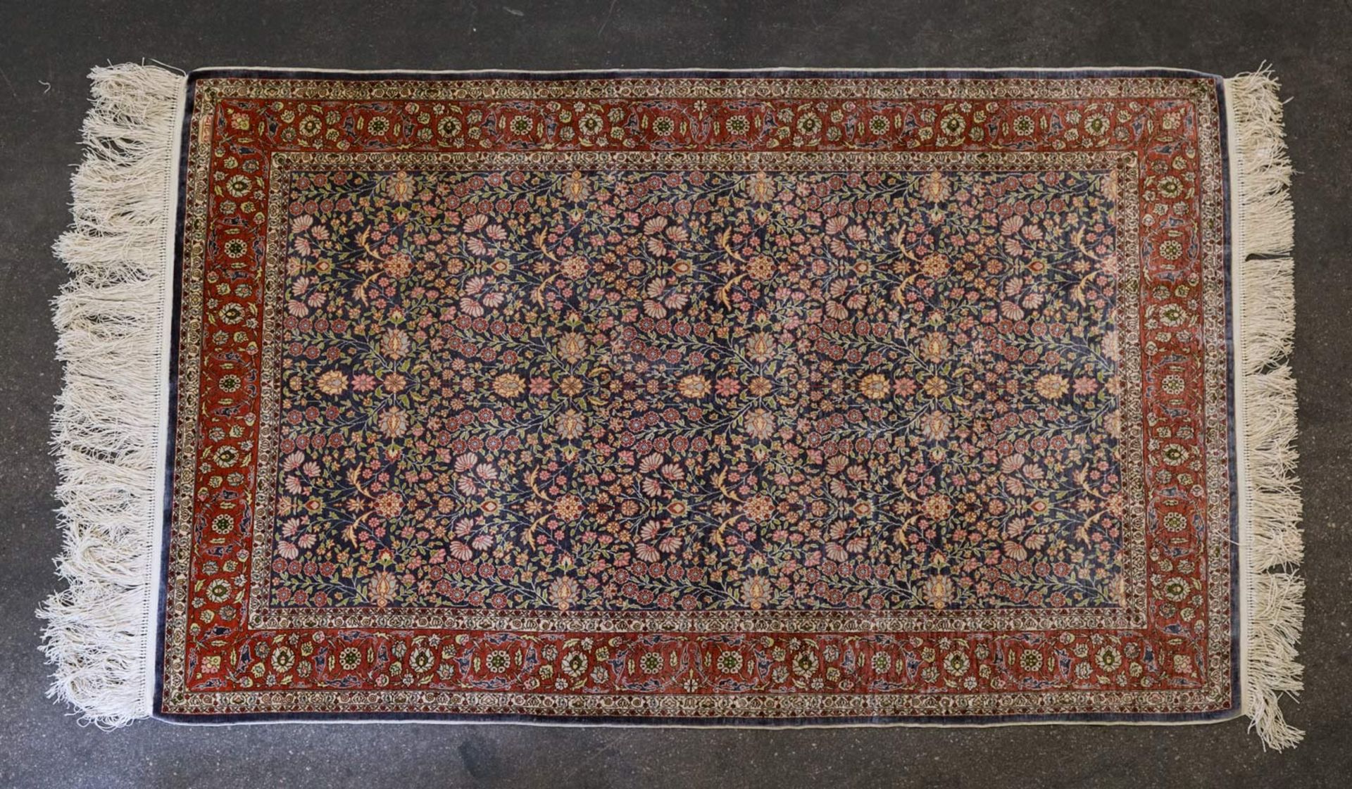 Orientteppich aus Seide. HEREKE/TÜRKEI, 20. Jh., ca. 171x109 cm der blaue Fond des Innenfeldes ist