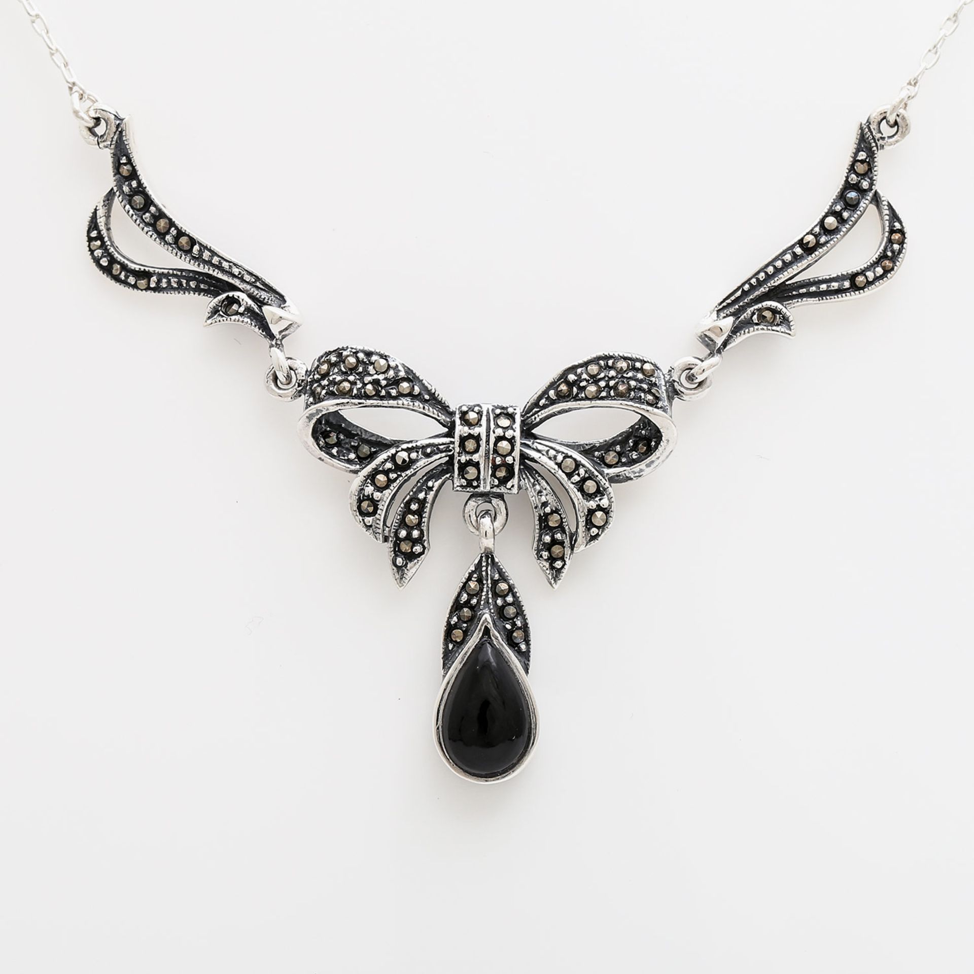 Collier in Schleifenform mit einem Onyx-Tropfen u. Markasiten in Silber. Sehr schöne Arbeit. L: