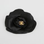 CHANEL edle Camelienblüten Brosche. Schwarz, mittig eingesetzter Knopf mit goldfarbenem CC-Logo. Box