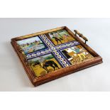 An oak two handled tray set with four majolica tiles one with Don Quiote 34 x 34 cm