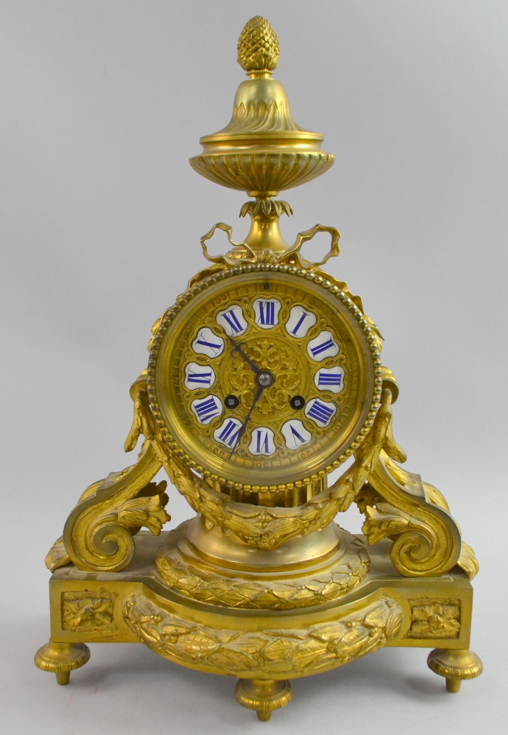 French Ormolu Clock with ribbon swag decoration white enamel and Blue Roman numerals, two train