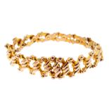 A late Victorian 9ct gold expandable bracelet. Designed as an articulated series of scrolling and