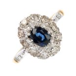 An 18ct gold sapphire and diamond cluster ring. The oval-shape sapphire, within a single-cut diamond