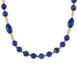 A lapis lazuli necklace. Comprised of oval and circular lapis lazuli beads, with twist and grooved