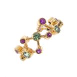 An 18ct gold ruby and tsavorite garnet dress ring. Designed as a series of vari-size circular-