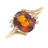 A citrine and diamond dress ring. The oval-shape citrine, with diamond accent asymmetric sides and