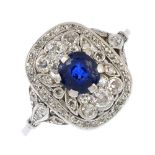 An Edwardian platinum sapphire and diamond ring. The cushion-shape sapphire, with vari-cut diamond