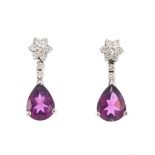 A pair of diamond and garnet earrings. Each designed as a pear-shape purple garnet, suspended from a