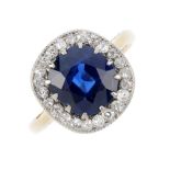 An early 20th century sapphire and diamond cluster ring. The cushion-shape sapphire, with old-cut