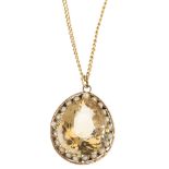 A citrine and seed pearl pendant. The pear-shape citrine, within a seed pearl openwork surround,