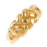 A late Victorian 18ct gold ring. Designed as a stylised knot panel, with openwork sides and a