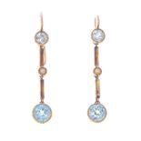 A pair of zircon and split pearl earrings. Each designed as a circular-shape blue zircon collet,