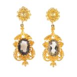 A pair of 9ct gold smoky quartz earrings. Each designed as an oval-shape smoky quartz, within a