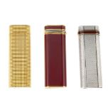 CARTIER - three lighters. To include a red lacquered trinity lighter, a silver-tone multi-textured