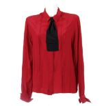 CHANEL - a red silk blouse. Designed with pleated detailing to the front and back, concealed front