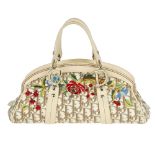CHRISTIAN DIOR - an embroidered Diorissimo canvas handbag. Crafted from maker's beige logo canvas